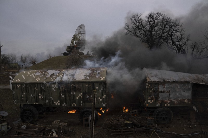 ロシア軍の攻撃を受け、煙が上がるウクライナ軍の施設=東部マリウポリ郊外で2022年2月24日、AP