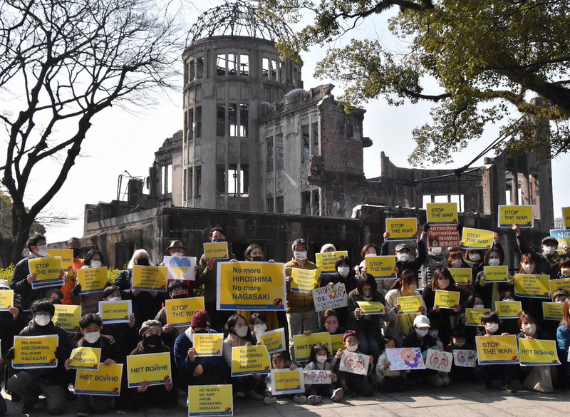 ロシアによるウクライナ侵攻に抗議する広島市民ら。「STOP THE WAR」「NO NUKES」のプラカードを掲げた=広島市中区の原爆ドーム前で2022年2月26日午前11時22分、小山美砂撮影
