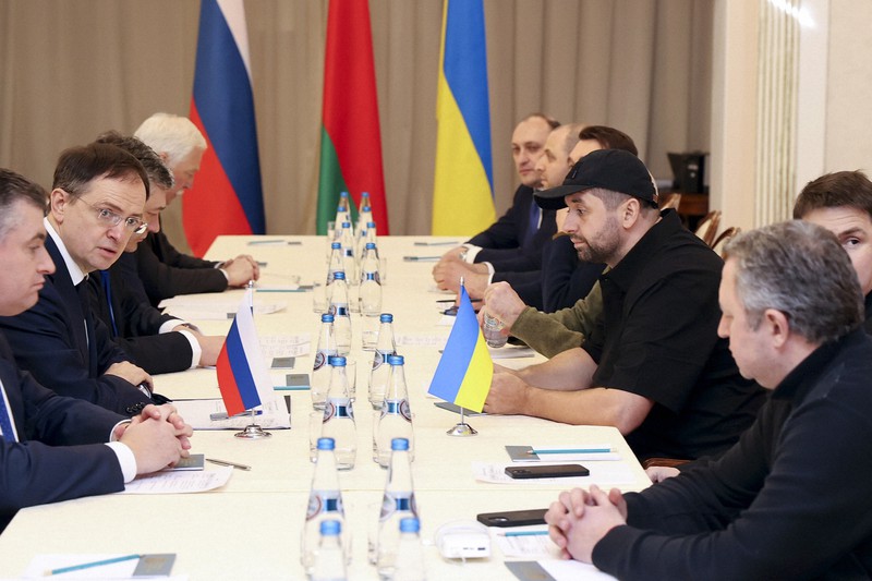 停戦協議に臨むロシア代表団(左側)とウクライナ代表団=ベラルーシ南東部ゴメリで2022年2月28日、AP