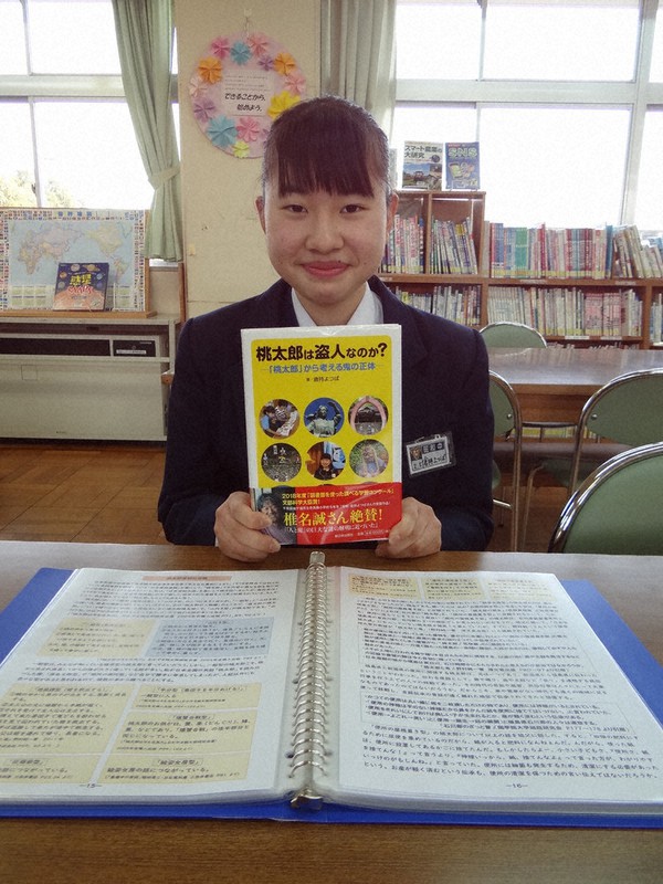 書籍化された前回の受賞作を手にする倉持よつばさん。手前は今回の受賞作=千葉県袖ケ浦市の昭和中学校で22年2月28日、浅見茂晴撮影