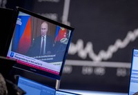 Russia's President Vladimir Putin appears on a television screen at the stock market in Frankfurt, Germany, on Feb. 25, 2022. (AP Photo/Michael Probst)