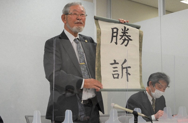 大阪地裁の判決後、「勝訴」と書かれた用紙を掲げて記者会見に臨む大阪府泉佐野市の代理人弁護士=大阪市内で2022年3月10日午後2時38分、芝村侑美撮影