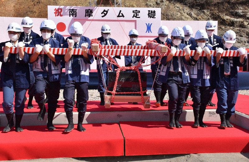 工事関係者らによって搬入される礎石=栃木県鹿沼市上南摩町で2022年3月12日、渡辺佳奈子撮影