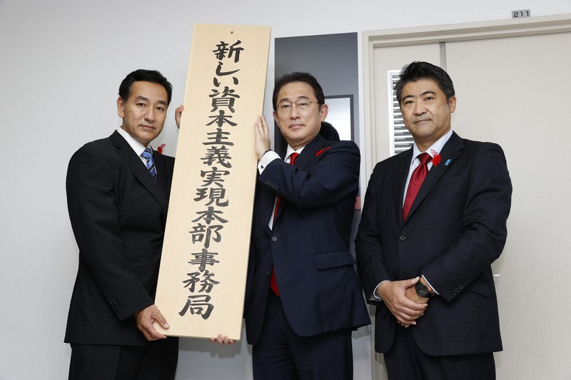 「新しい資本主義実現本部事務局」の看板を掲げる(左から)山際大志郎経済再生担当相と岸田文雄首相、木原誠二官房副長官=東京・永田町の内閣府で(代表撮影)