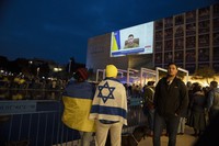 People gather in Habima Square in Tel Aviv, Israel, to watch Ukrainian President Volodymyr Zelenskyy in a video address to the Knesset, Israel's parliament, on March 20, 2022. (AP Photo/Maya Alleruzzo)