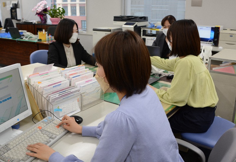 制服着用義務が廃止され、スーツやブラウス姿で働く佐賀共栄銀行の女性行員たち=福岡市博多区で2022年3月17日午後4時57分、久野洋撮影