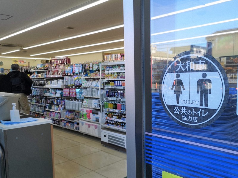 公共トイレ協力店のコンビニエンスストア入り口に貼られたステッカー=神奈川県大和市で2022年2月24日午後3時46分、池田直撮影