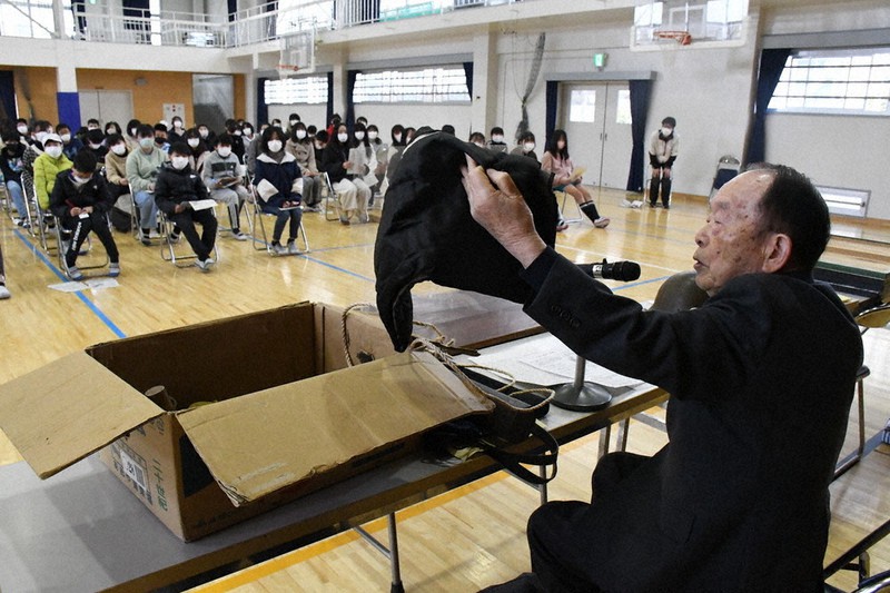 戦時中に使われた物を見せながら、平和な未来を願って語り続ける黒田権大さん=兵庫県姫路市延末の市立手柄小で、阿部浩之撮影