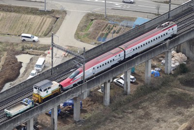 脱線現場から白石蔵王駅（左）へ牽引される東北新幹線の車両＝宮城県白石市で2022年3月27日午前9時14分、本社ヘリから