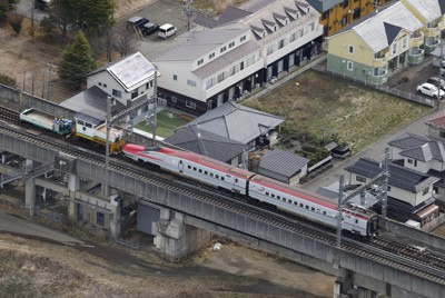 脱線現場から白石蔵王駅（左側）へけん引される東北新幹線の車両＝宮城県白石市で2022年3月27日午前9時16分、本社ヘリから