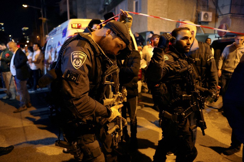 テロ事件の現場付近で警戒に当たる警察官=イスラエル中部テルアビブ近郊で29日、ロイター