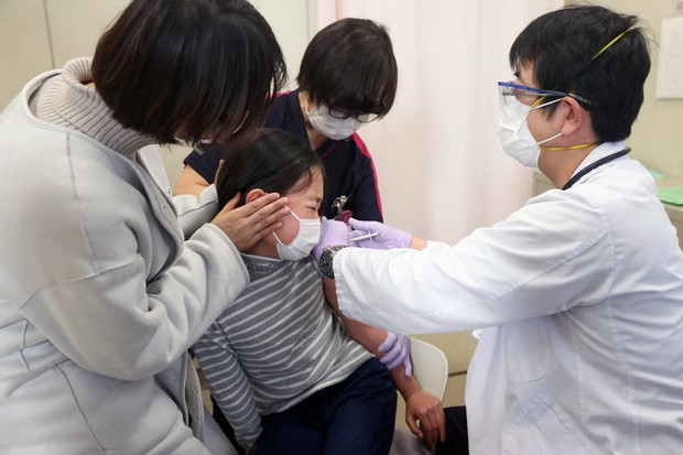 新型コロナウイルスのワクチン接種を受ける子ども(中央)=東京都墨田区の同愛記念病院で2022年2月28日、佐々木順一撮影