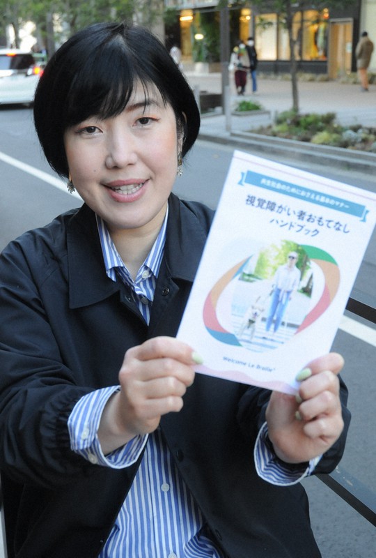 「視覚障がい者おもてなしハンドブック」を手にする佐藤優子さん=東京都内で2022年2月25日午後2時35分、谷本仁美撮影