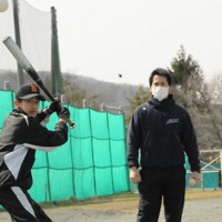 グラウンドの片隅で練習に励む仙台市立館中学校野球部の天谷夏生さん（左）と指導する千葉志行教諭＝仙台市で2022年3月25日、村上正撮影
