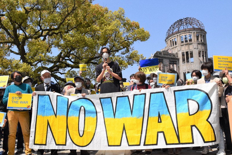 原爆ドーム前でウクライナの平和を祈り、戦争反対と核兵器の使用禁止を訴える参加者ら=広島市中区で2022年4月10日午前11時25分、根本佳奈撮影