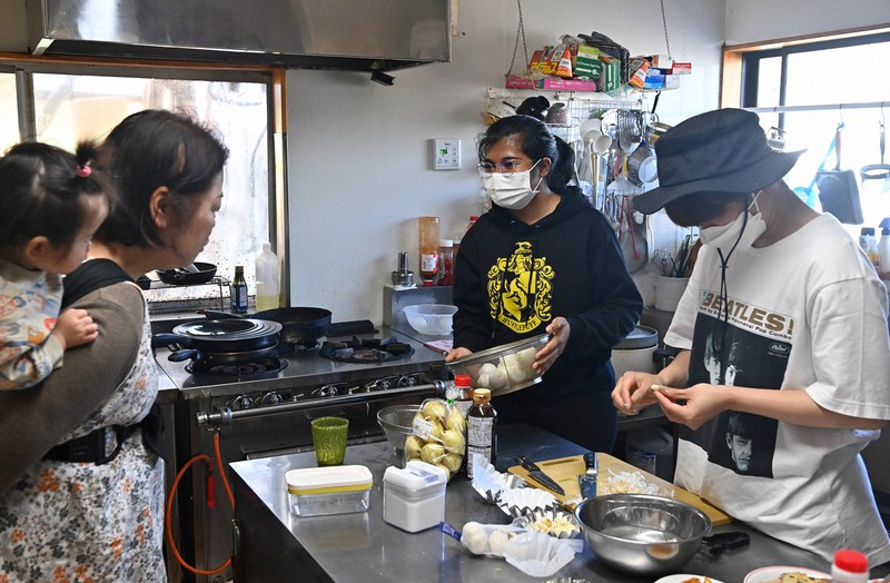 竹原伊都子さん(左)を手伝うインド人留学生のシバンカル・パラビさん(中央)=熊本県南阿蘇村で2022年4月9日、平川義之撮影