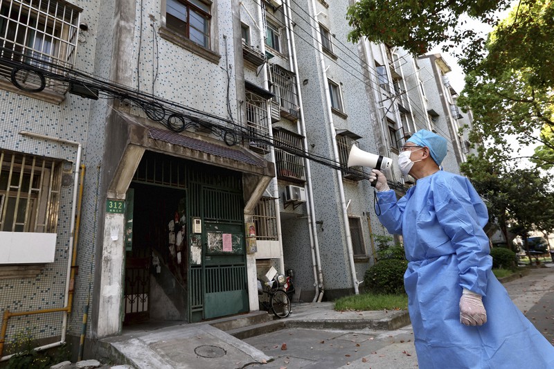 中国・上海のアパートでは、新型コロナウイルスの感染が広がり、メガホンを使って住民と話をする人の姿が見られた=新華社AP