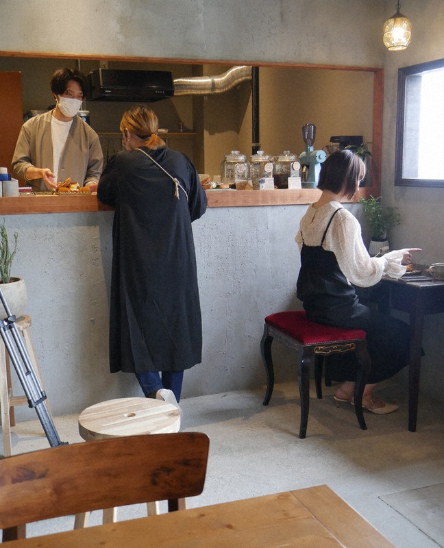 開店した「あいぞめ珈琲店」。店主の中野裕基さん(左)は「店を住民が前向きになるきっかけにしたい」と話す=静岡県熱海市伊豆山で2022年4月15日、長沢英次撮影