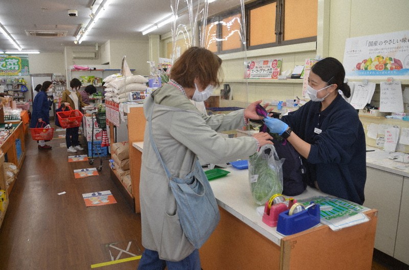 直売所でにこやかに接客する角出閑さん(右)=滋賀県彦根市平田町で、伊藤信司撮影