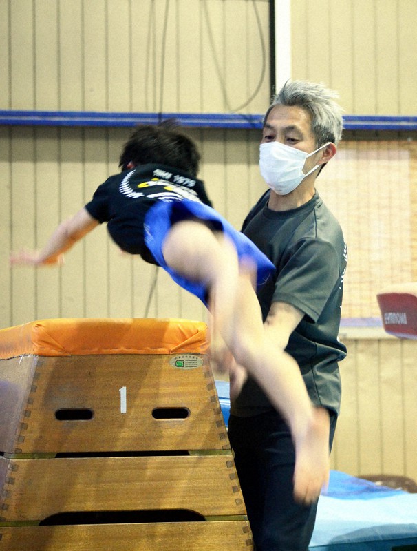 跳び箱を跳ぶ生徒を左腕で補助する相原豊指導主任=群馬県高崎市の相原体操クラブで2022年4月11日午後6時17分、近藤浩之撮影