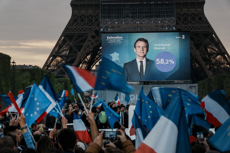 エッフェル塔の前に集まった、マクロン大統領の支持者ら=2022年4月24日、AP