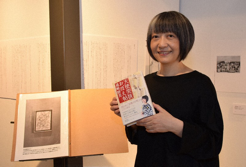 収録できなかった原稿も展示している会場で、著書を手にする通崎睦美さん=京都市下京区の大垣書店京都本店で、南陽子撮影