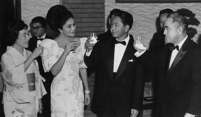 1966年に訪日したマルコス大統領(中央)とイメルダ夫人(左)。佐藤栄作首相と乾杯する=肩書はいずれも当時