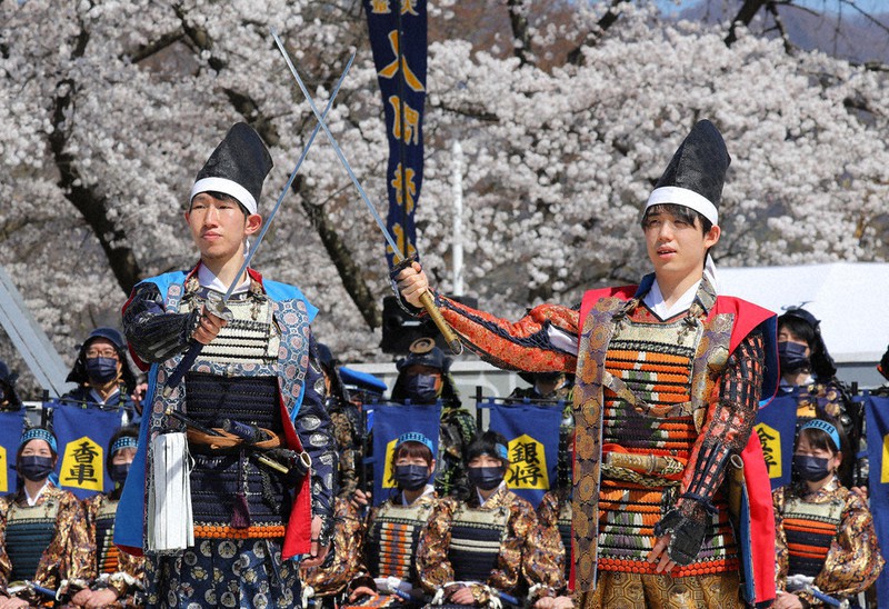山形県天童市で行われた恒例のイベント「人間将棋」にも「リアル王将」として登場。対局を終え、記念撮影に応じる藤井王将（右）と佐々木大地六段＝山形県天童市で17日、長谷川直亮撮影