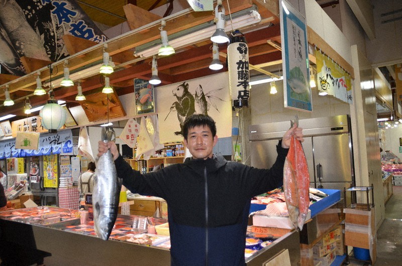 「ボダッコ」(紅鮭)を手にする加藤本店の加藤真さん=秋田市の「秋田市民市場」で2022年4月26日、工藤哲撮影