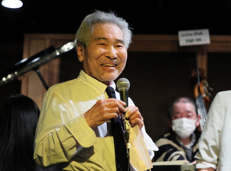 演奏の合間にマイクを握り、50年間の思い出を語る鳴海廣さん=青森市で2022年5月8日、近藤卓資撮影
