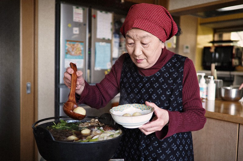 だまこ鍋を器によそう石井邦子さん=秋田県五城目町の石井さん宅で2022年4月撮影