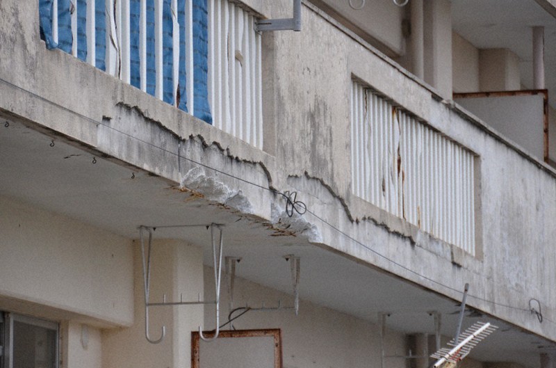 コンクリートが剥がれ、鉄筋がむき出しになった親田原市営住宅=沖縄県糸満市で2022年5月2日、竹内望撮影