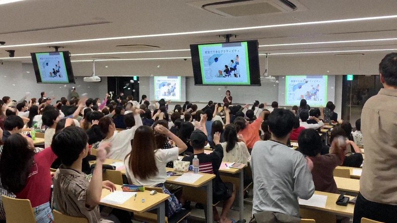 出口真紀子さんの授業風景。大学生たちが紙ボールを一斉に投げているところ=出口さん提供