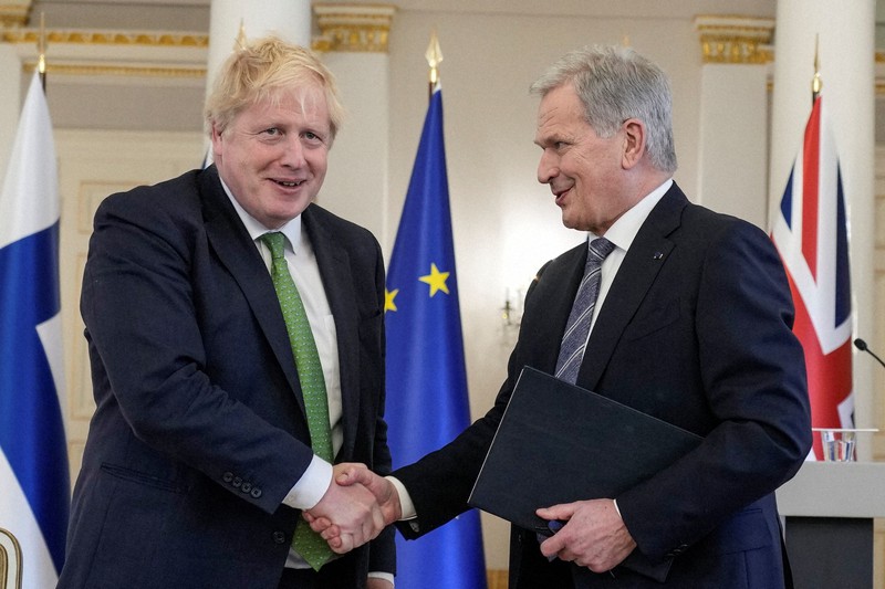軍事支援を表明したジョンソン英首相(左)と握手するフィンランドのニーニスト大統領=ヘルシンキで2022年5月11日、ロイター
