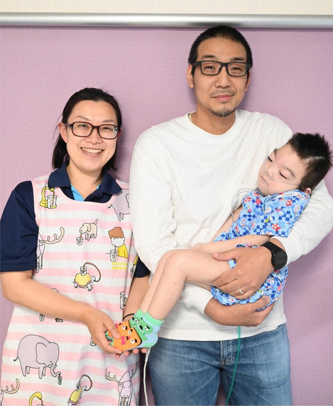 次男の愛樹ちゃんを抱く長谷川貴嗣さん(右)と仁美さん=栃木県下野市緑6の多機能型重症児デイサービス「DAIJI」で2022年5月10日、御園生枝里撮影