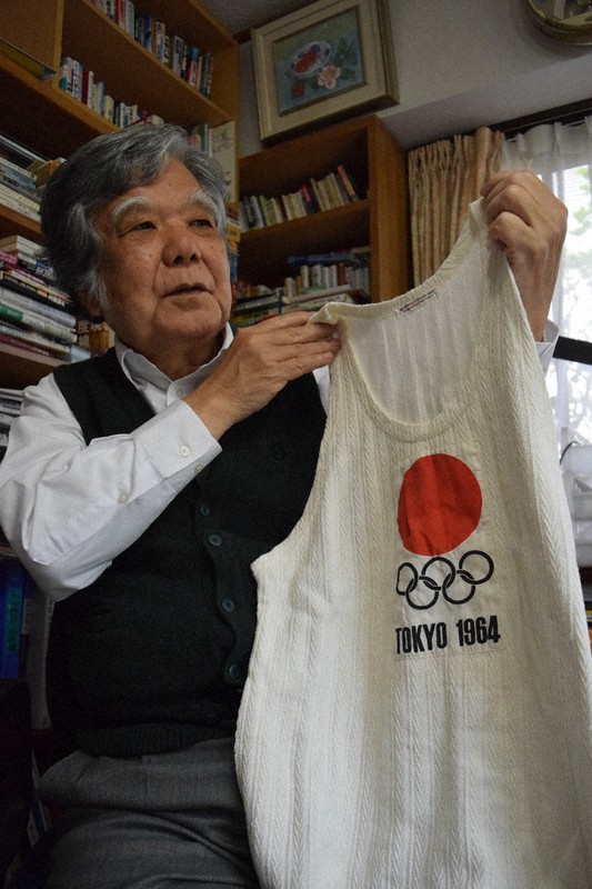 1964年東京オリンピックの聖火リレーで着たユニホームを懐かしむ崎浜盛喜さん=奈良市で、塩路佳子撮影