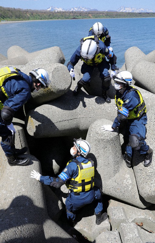 波消しブロックの間を捜索する道警の警察官ら=北海道標津町で2022年5月16日、貝塚太一撮影
