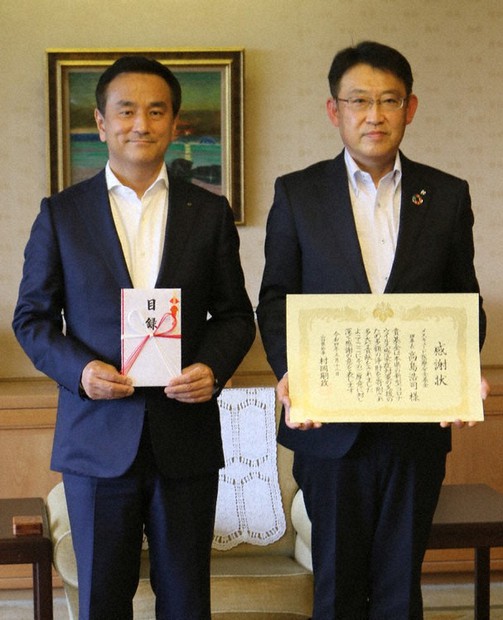 県に100万円を寄付したメスキュード医療安全基金の今枝・共英製鋼山口事業所メスキュード部長(右)と村岡知事