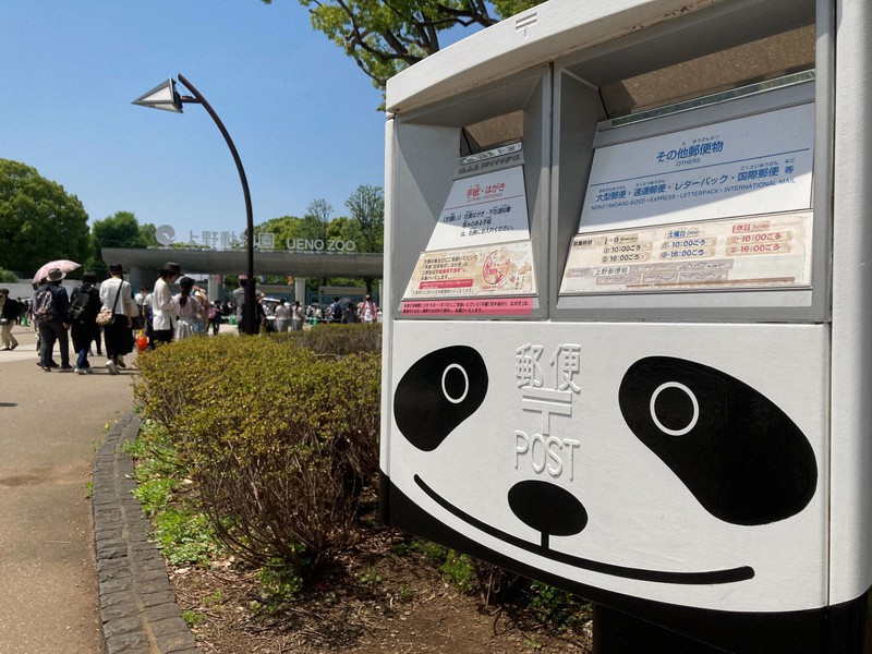 上野動物園正門(奥)と上野公園内に設置されたパンダ柄の郵便ポスト=東京都台東区で2022年5月、松井勇人撮影