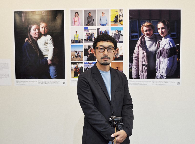 今年3月にポーランドでウクライナからの避難者を撮影した写真家の小原一真さんと作品=東京都府中市の東京外国語大学で2022年5月16日、遠藤和行撮影