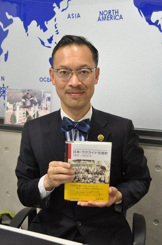著書を手にする神戸学院大の岡部芳彦教授=神戸市中央区で、関谷徳撮影