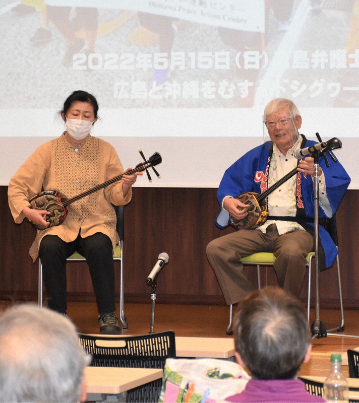 「三線」を演奏する中村盛博さん(右)ら=広島市中区の広島弁護士会館で、根本佳奈撮影