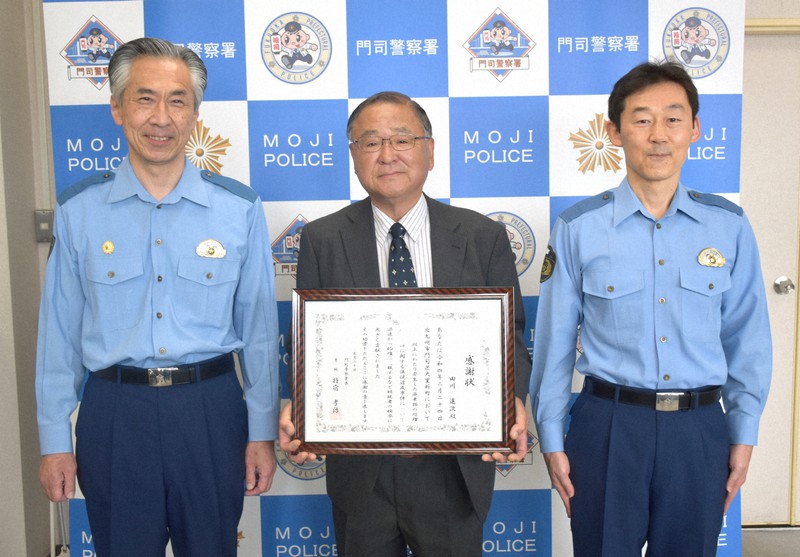 感謝状を受け取った田川さん(中央)=北九州市門司区の門司警察署で2022年5月20日午前10時33分、林大樹撮影