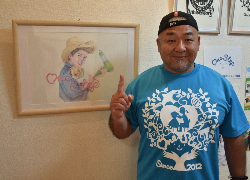 ワンステップ代表の丸井教彰さん。イベント会場では、活動をイメージして描かれたイラストなどが展示されている=千葉県八千代市で2022年4月28日、真田祐里撮影
