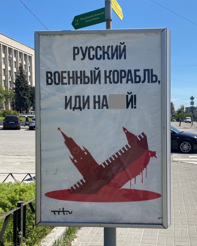 「ロシアの軍艦め、くそ食らえ!」とロシア語で書かれたポスター。クレムリン(露大統領府)の時計台と軍艦を合体させた異形の船が海に沈んでいくイラストが描かれている=ウクライナ南部ザポロジエで2022年5月6日午後、真野森作撮影(画像の一部を加工しています)