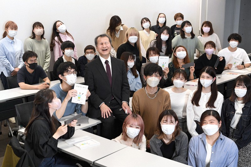点字の講座を受講する学生に囲まれ、笑顔を見せる堀越喜晴さん(中央左)=埼玉県新座市の立教大新座キャンパスで2022年4月26日、竹内紀臣撮影