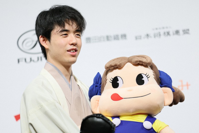 第7期叡王戦で3連勝して初防衛を果たし、「ペコちゃん」の人形を手に写真撮影に応じる藤井聡太叡王＝千葉県柏市で2022年5月24日午後7時56分、吉田航太撮影