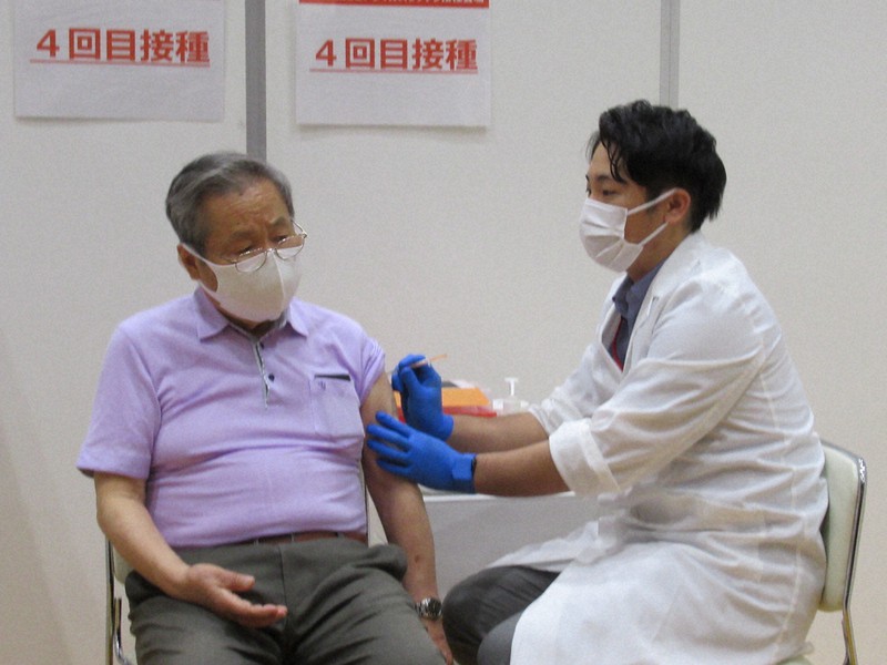 新型コロナウイルスワクチンの4回目の接種を受ける男性(左)=東京都港区芝5の港区新型コロナワクチン接種センターで2022年5月25日午前9時40分、山縣章子撮影