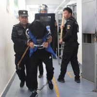 中国新疆ウイグル自治区テケス県の拘置所での訓練とみられる画像。収容者が手錠、足かせ、覆面をつけられ連れ出されている。画像データによると、2018年9月25日午後4時31分35秒に撮影された＝「新疆公安ファイル」より