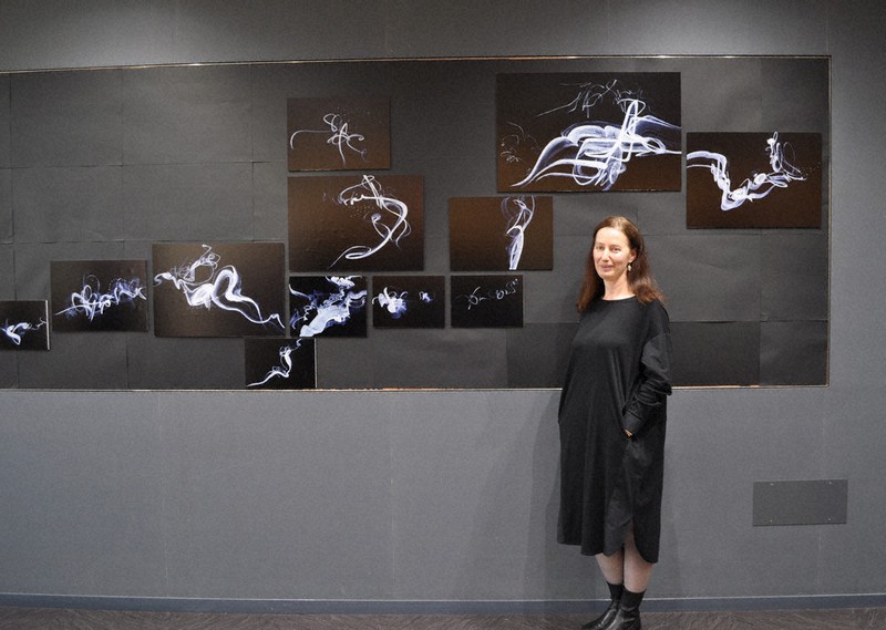 ロシア出身画家の「煙」を描いた作品の前に立つ、美術展発案者のレーナ・アフラーモワさん=府中市の東京外国語大学で2022年5月16日、遠藤和行撮影